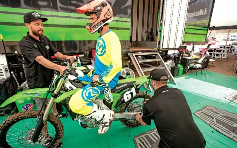 Mechanik sprawdza ustawienie sag w motocyklu, pomagając zawodnikowi w przygotowaniach do wyścigu.