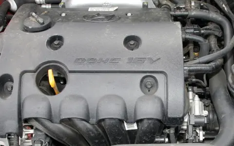 Silnik samochodowy z napisem DOHC 16V. DOHC to skrót od "Double Overhead Camshaft", co oznacza podwójny wałek rozrządu umieszczony nad głowicą.