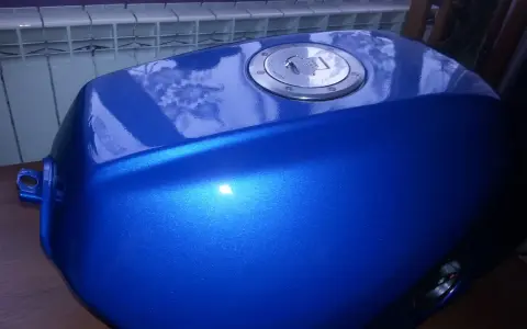 Błękitny, lśniący bak motocyklowy po malowaniu plastików. Metaliczny połysk podkreśla efektowne malowanie.