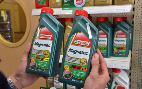 Ręce trzymają butelki oleju silnikowego Castrol Magnatec. Czy Castrol to dobry olej? Ten produkt zapewnia natychmiastową ochronę silnika.