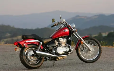 Czerwony motocykl Kawasaki EN 500 na tle górskich krajobrazów. Dane techniczne tego modelu to świetny wybór dla miłośników klasycznych cruiserów.