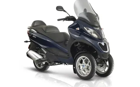 Granatowy Piaggio MP3 300 z trzema kołami, dużą szybą i wygodnym siedzeniem. Poznaj jego piaggio mp3 300 dane techniczne.