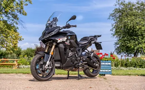 Czarny motocykl BMW S1000 XR na postoju, gotowy do podróży. Poznaj jego bmw 1000 xr dane techniczne i ruszaj w drogę!