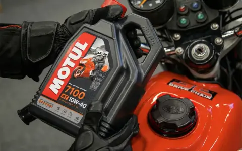 Rękawice motocyklowe trzymają olej Motul 7100 10W-40. Sprawdź, co ile wymieniać olej w motocyklu, by zapewnić mu długą żywotność.