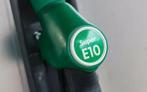 Zielony dystrybutor paliwa z napisem "Super E10". Zastanawiasz się, jakie paliwo do motocykla? E10 to opcja.