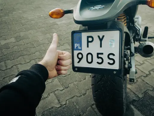 Kciuk w górę przy rejestracji starego motocykla z dokumentami. PY 905S.