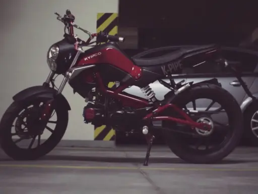 Czerwony Kymco K-Pipe, idealny do obliczenia stosunku mocy do masy.