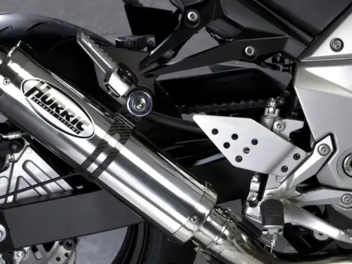 Błyszczący tłumik motocyklowy Hurric, element układu wydechowego, który może pomóc w uzyskaniu basowego brzmienia.