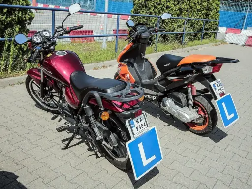 Dwa motorowery z tabliczkami "L" sugerują, że to nauka jazdy. Karta motorowerowa od ilu lat? Od 14.