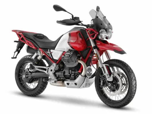Czerwono-biały motocykl Moto Guzzi V85 TT z czarnym siedzeniem i akcentami, gotowy na przygodę.