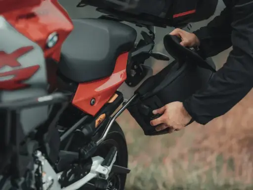 Przygotowanie do wyprawy: montaż sakwy do motocykla na malownicze **trasy motocyklowe Wielkopolska**.