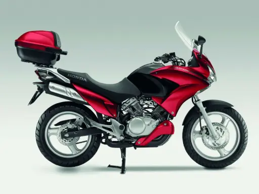 Czerwony motocykl Honda Varadero 125 z kufrem, gotowy na odblokowanie mocy i przygodę.