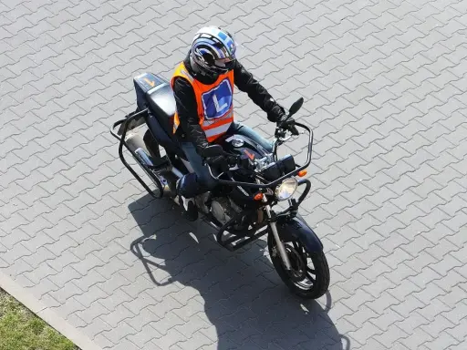 Motocyklista w kamizelce z literą "L" na placu manewrowym. Czy to nauka jazdy na motorze o pojemności 250cc, by zdobyć a2 prawo jazdy?