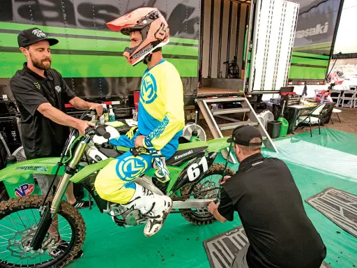 Mechanik sprawdza ustawienie sag w motocyklu, pomagając zawodnikowi w przygotowaniach do wyścigu.