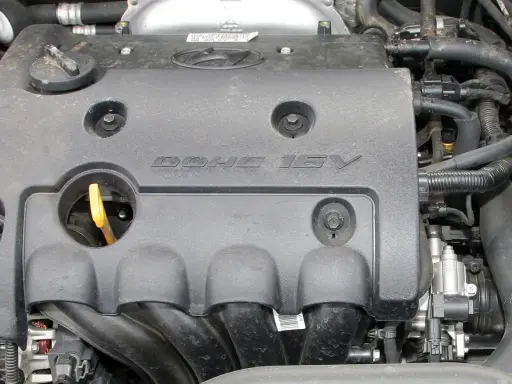 Silnik samochodowy z napisem DOHC 16V. DOHC to skrót od "Double Overhead Camshaft", co oznacza podwójny wałek rozrządu umieszczony nad głowicą.