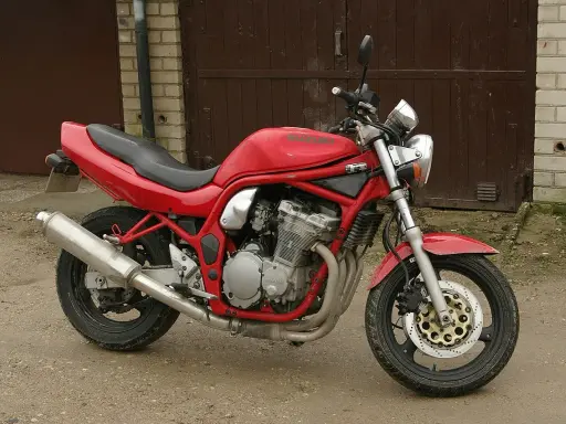 Czerwony Suzuki Bandit 600, gotowy do jazdy, z widocznym silnikiem i wydechem.