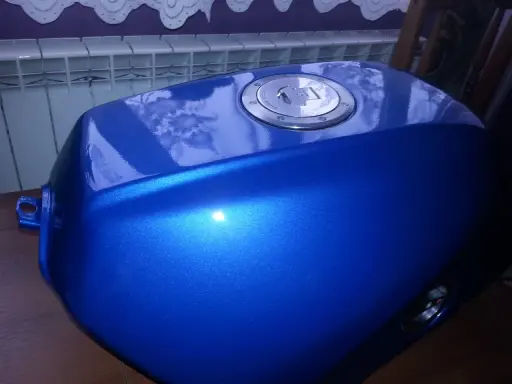 Błękitny, lśniący bak motocyklowy po malowaniu plastików. Metaliczny połysk podkreśla efektowne malowanie.