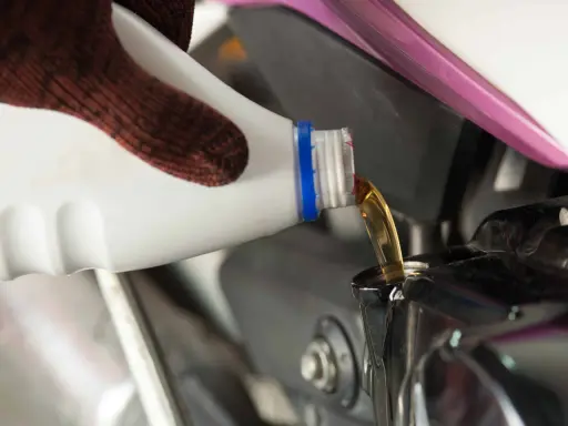 Rękawica nalewa nowy olej do silnika motocykla podczas wymiany oleju.