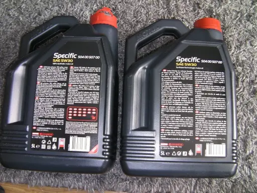 Dwie czarne bańki oleju silnikowego Motul Specific SAE 5W30. Sprawdzenie oryginalności produktu jest kluczowe.