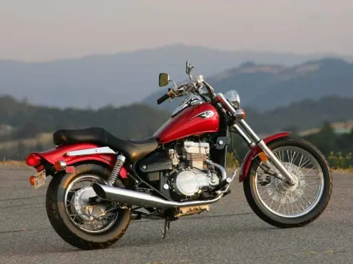 Czerwony motocykl Kawasaki EN 500 na tle górskich krajobrazów. Dane techniczne tego modelu to świetny wybór dla miłośników klasycznych cruiserów.