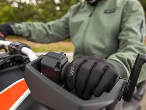 Rękawiczka motocyklisty na kierownicy. Dowiedz się, jak sprawdzić żywotność akumulatora, by zawsze ruszyć w drogę.