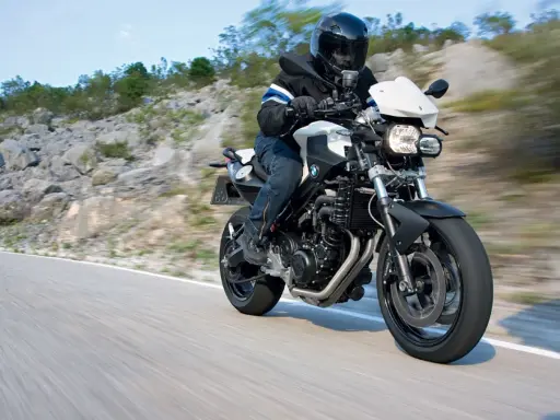 Motocyklista w kasku jedzie na BMW F800R po krętej drodze. Poznaj jego dane techniczne.