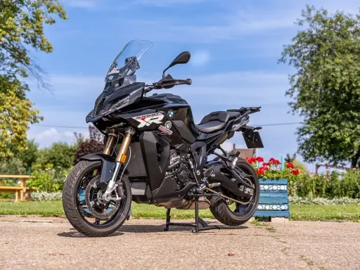 Czarny motocykl BMW S1000 XR na postoju, gotowy do podróży. Poznaj jego bmw 1000 xr dane techniczne i ruszaj w drogę!