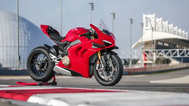 Czerwona Ducati Panigale V4 na torze wyścigowym, gotowa do jazdy.