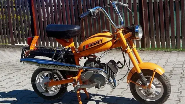 Pomarańczowy Romet, jeden z klasycznych nowych polskich motocykli, gotowy do jazdy po bruku.