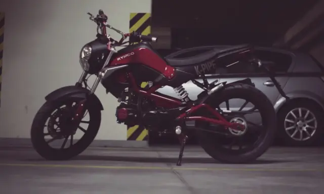 Czerwony Kymco K-Pipe, idealny do obliczenia stosunku mocy do masy.