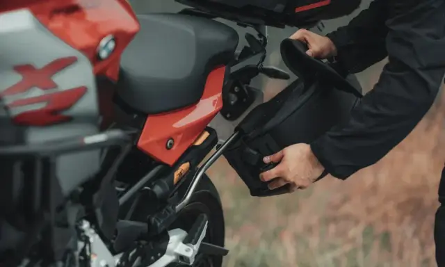 Przygotowanie do wyprawy: montaż sakwy do motocykla na malownicze **trasy motocyklowe Wielkopolska**.