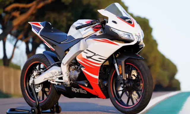 Sportowy motocykl Aprilia RS 125 2T, biało-czerwony, z widocznymi detalami i napisem "RS". Idealny do poznania jego aprilia rs 125 2t dane techniczne.