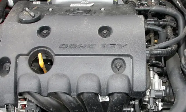 Silnik samochodowy z napisem DOHC 16V. DOHC to skrót od "Double Overhead Camshaft", co oznacza podwójny wałek rozrządu umieszczony nad głowicą.