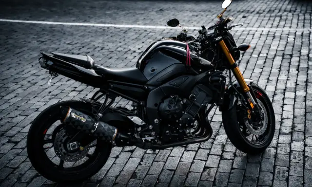 Czarny motocykl na bruku, gotowy do sprowadzenia motocykli z USA.