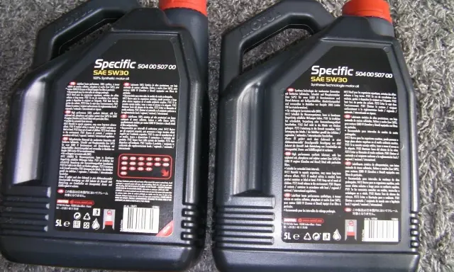 Dwie czarne bańki oleju silnikowego Motul Specific SAE 5W30. Sprawdzenie oryginalności produktu jest kluczowe.