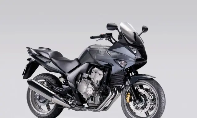 Szary motocykl Honda CBF 600, zgrabny i sportowy, idealny dla osób szukających komfortu i odpowiedniej wysokości siedzenia.