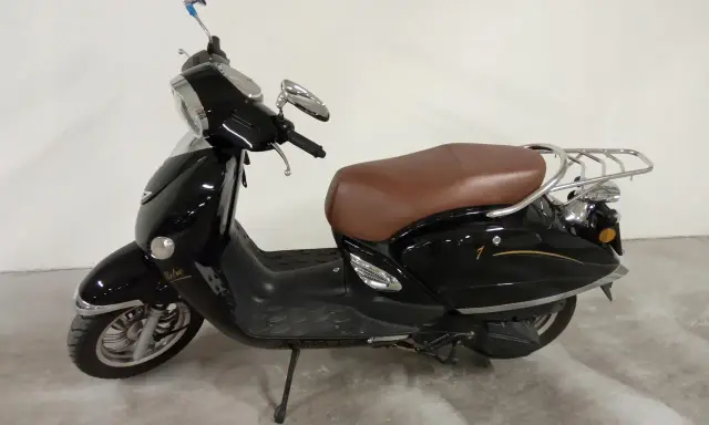 Czarny skuter Romet Retro 7 50 z brązowym siedzeniem i chromowanymi elementami, gotowy na retro podróż.