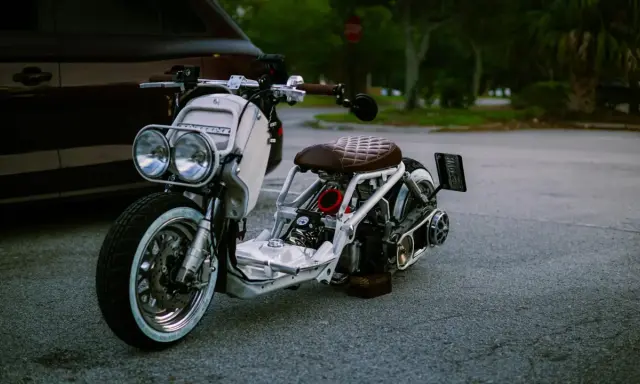 Zmiana cylindra z 50 na 70 2t w białym skuterze z brązowym siedzeniem.