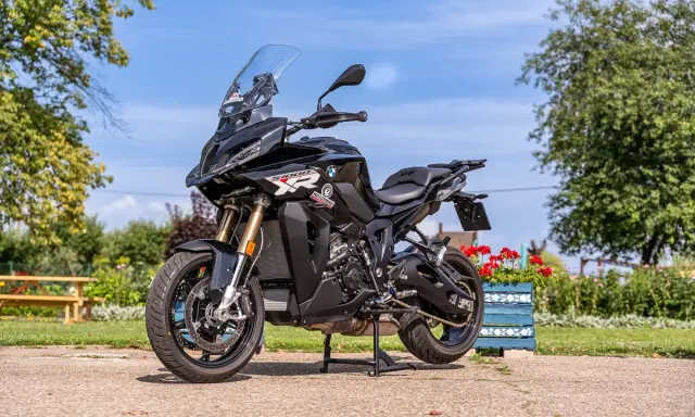 Czarny motocykl BMW S1000 XR na postoju, gotowy do podróży. Poznaj jego bmw 1000 xr dane techniczne i ruszaj w drogę!