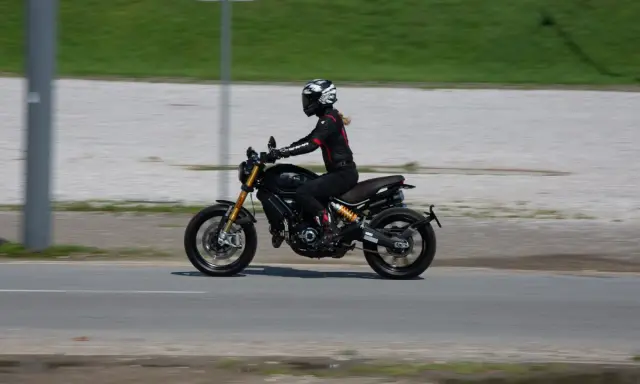 Kobieta w kasku i kombinezonie jedzie motocyklem spełniającym normę **euro 4**.