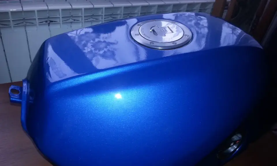 Błękitny, lśniący bak motocyklowy po malowaniu plastików. Metaliczny połysk podkreśla efektowne malowanie.