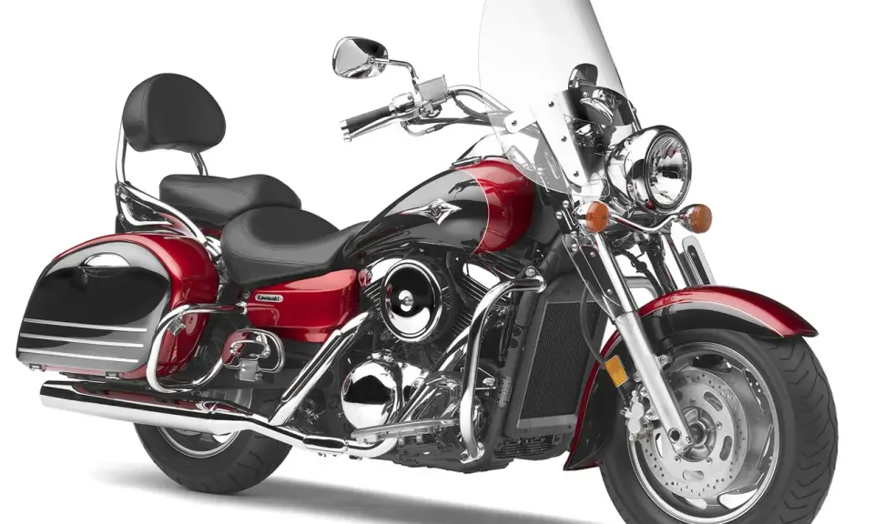 Czerwony motocykl Kawasaki VN 1600 z sakwami i dużą szybą. Choć piękny, jego wady mogą dotyczyć wygody pasażera.