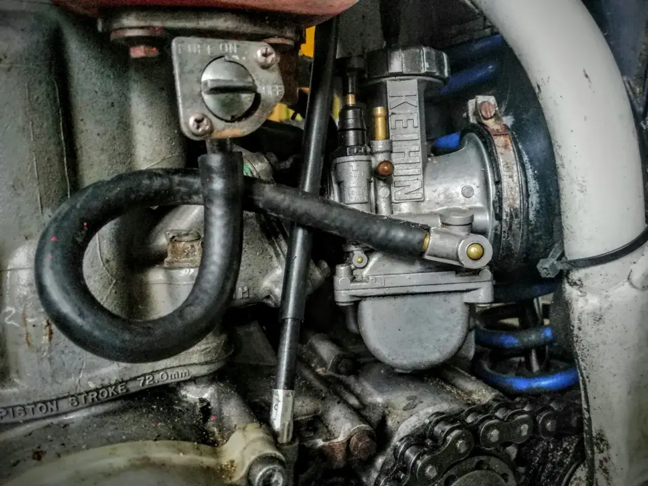 Silnik motocykla z gaźnikiem Keihin. Widoczne objawy za wysokiego poziomu paliwa w gaźniku, jak przelew paliwa.