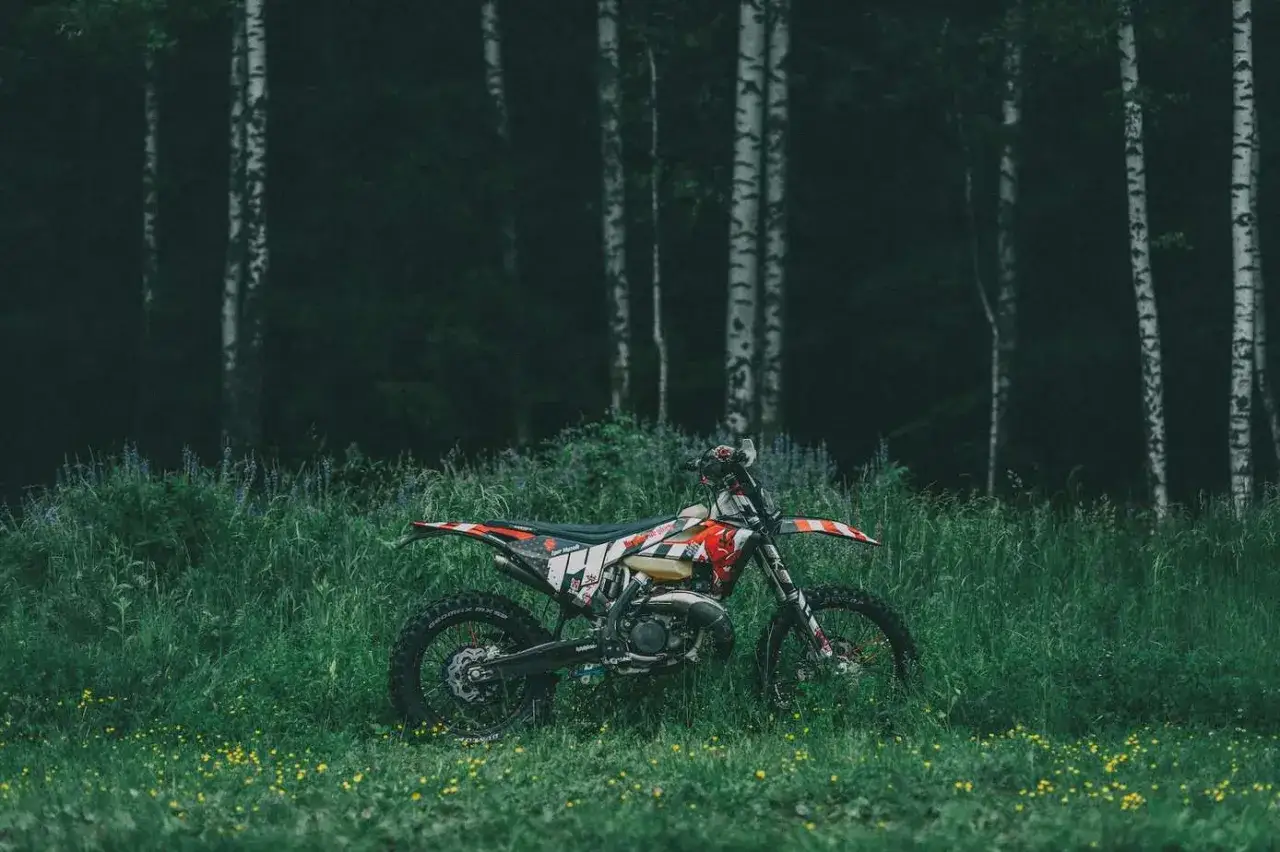 Motocykl crossowy w trawie, idealne miejsce, gdzie można jeździć crossem.
