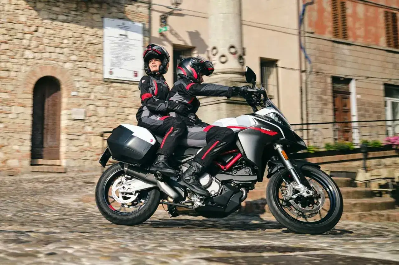 Para na motocyklu do turystyki we dwoje przemierza urokliwe, brukowane uliczki.