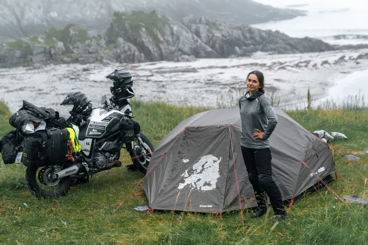 Kobieta obok namiotu z mapą Europy i motocyklem przygotowanym do podróży. Idealny namiot na motocykl na wyprawę.