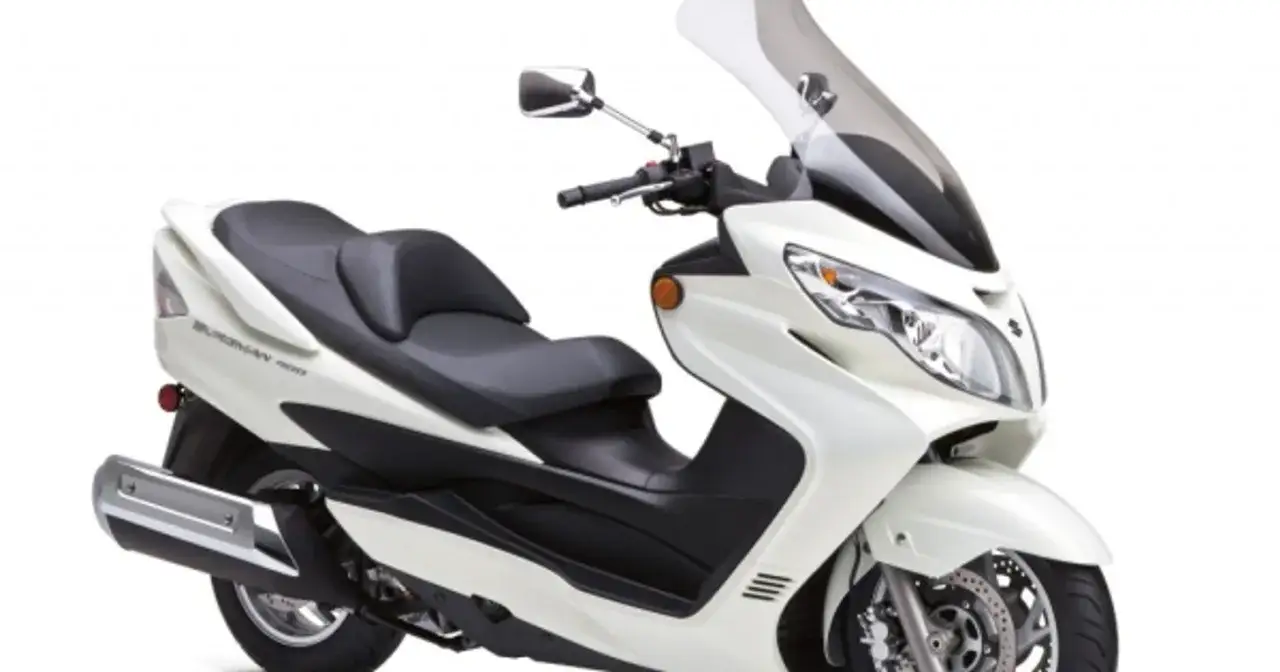 Biały Suzuki Burgman 400, skuter z wygodnym siedzeniem i dużą szybą. Idealny do miasta i na dalsze trasy, choć ma swoje wady i zalety.