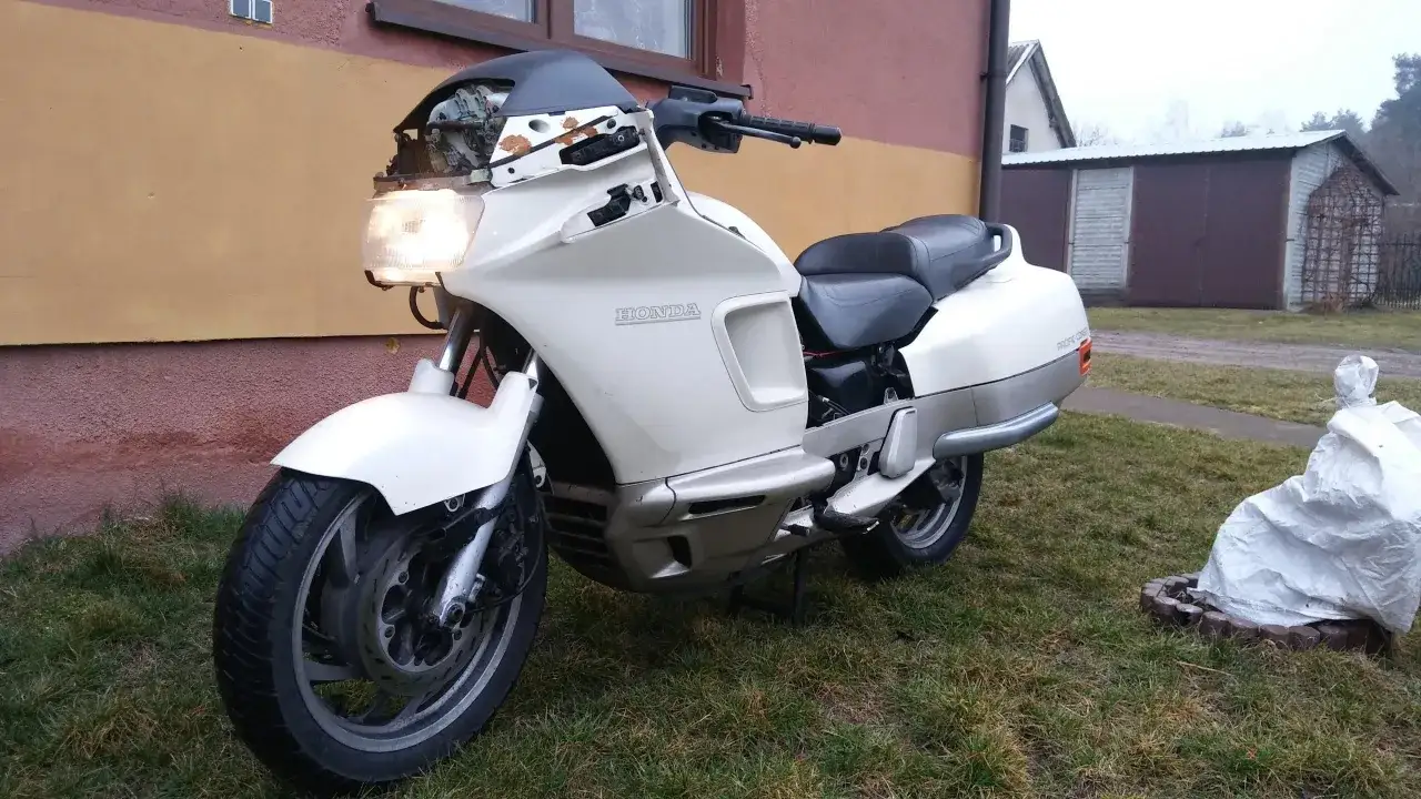 Biały motocykl Honda PC 800 Pacific Coast, z widocznymi elementami deski rozdzielczej i siedzeniem. Dane techniczne tego modelu są imponujące.