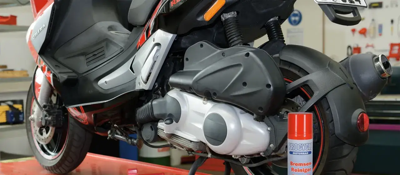 Skuter Gilera z widocznym elementem napędu. Puszka środka do czyszczenia hamulców sugeruje, że mogą być badane objawy zużytego wariatora w skuterze.