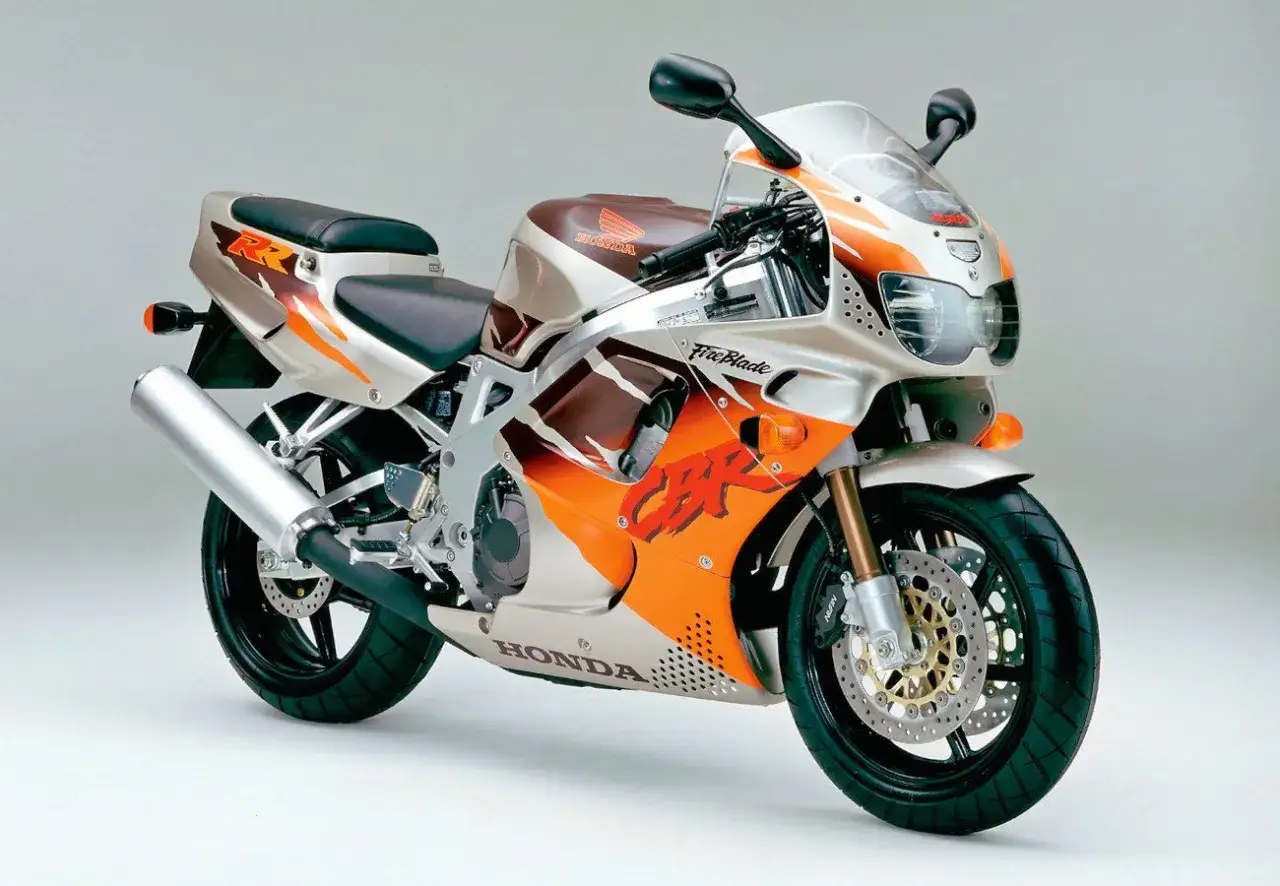 Sportowy motocykl Honda CBR Fireblade z lat 90. w kolorze srebrnym, brązowym i pomarańczowym.